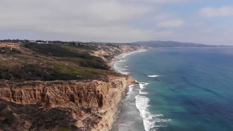 Waves-crash-as-drone-rotates-around-cliffs-at-Torrey-Pines