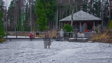 Time-lapse-shot-showing-group-of-people-ice-skating-on-frozen-lake-in-nature,-eating-and-drinking-outdoors-during-cold-winter-day-during-holidays