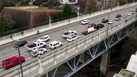 Canadian-Flags-And-Banner-On-Vehicles-At-Burrard-Street-Bridge-In-Vancouver,-Canada