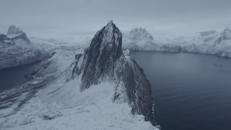 Aerial-drone-view-approaching-the-snowy-Segla-mountain,-blue-hour-in-Senja,-Norway
