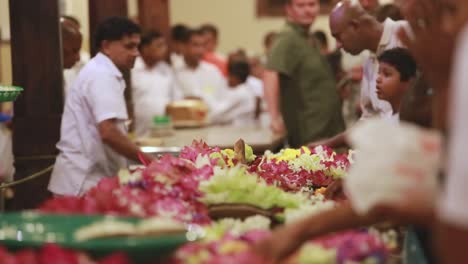 Vista-De-Personas-Reunidas-Para-Comprar-Flores-De-Un-Vendedor-Para-Ofrecerlas-En-El-Templo