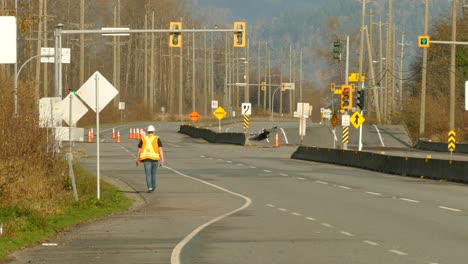 Male-road-worker-walks-on-a-closed-road-due-to-works-and-destroyed-asphalt