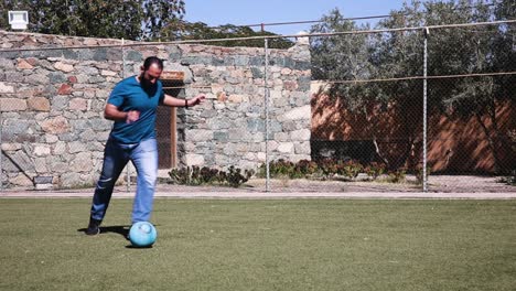 Slomo-gimbal-shot-of-man-in-casual-clothes-kicking-soccer-ball