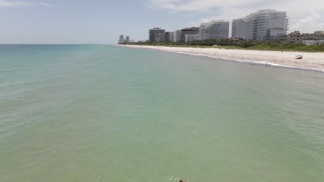 Luftaufnahme:-Eine-Einsame-Junge-Frau-Schwimmt-Am-Surfside-Beach-In-Miami-Ans-Ufer