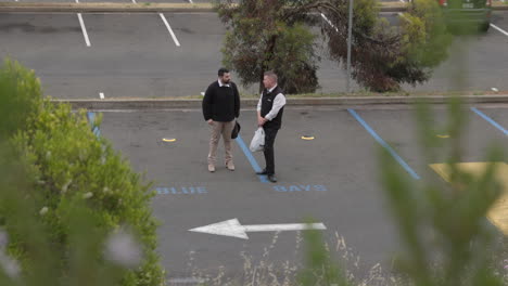 Two-Office-Workers-Talking-Having-Business-Meeting-In-A-Car-Park-Lot-During-The-Day