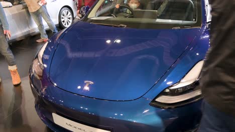 A-visitor-opens-the-engine-hood-of-a-Tesla-Model-3-at-the-American-electric-company-car-Tesla-Motors-booth-during-the-International-Motor-Expo-showcasing-EV-electric-cars-in-Hong-Kong