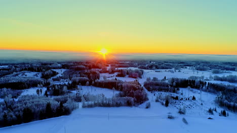 Beautiful-snow-covered-landscape-with-sunrise-in-the-horizon-on-a-chilly-winter-morning