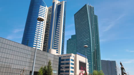 Gimbal-Aufnahme-Der-Innenstadt-Der-Hauptstadt-Astana,-Nursultan,-Moderne-Neofuturistische-Architektur-Skyline-Mit-Bronzeskulptur-Auf-Dem-Berühmten-Boulevard