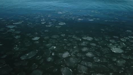 Große-Aufnahme-Von-Eis,-Das-Auf-Der-Glatten-Oberfläche-Des-Lake-Ontario-Schwimmt-Und-Aufbricht