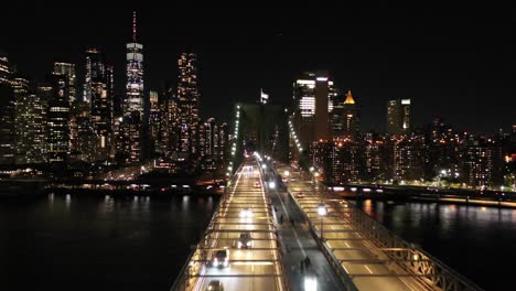 Una-Toma-Lenta-Y-Baja-De-Drones-Del-Horizonte-De-Nueva-York-Desde-El-Puente-De-Brooklyn-Por-La-Noche