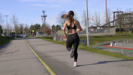 Athletic-woman-running-away-from-camera-angle-gimbal-shot
