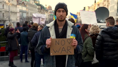Pacifist-with-protest-sign-at-a-rally-against-war-in-Ukraine,-Prague