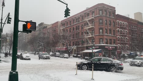 El-Coche-Hace-Girar-Los-Neumáticos-En-La-Calle-De-La-Ciudad-De-Nueva-York-Con-Los-Coches-De-Policía-Pasando-Por-La-Nieve-Pesada