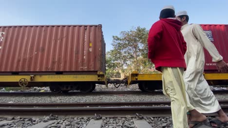 Transport-Von-Frachtcontainern-Im-Vorbeifahrenden-Güterzug-Mit-Vorbeigehenden-Bengalischen-Menschen