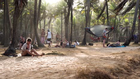 Men-and-women-passing-time-at-tribal-gathering-campsite-on-a-windy-day,-Handheld-wide-shot