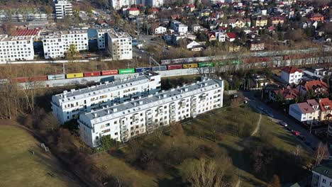 Aerial-view-around-a-apartment-building-and-a-train-in-sunny-Warsaw-city,-in-Poland---orbit,-drone-shot