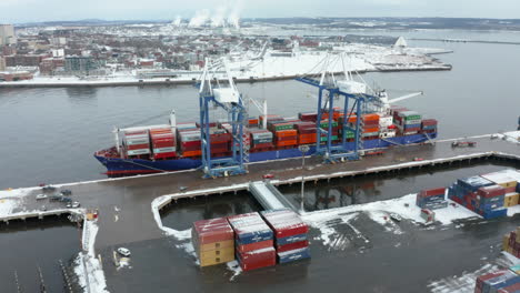 Aerial-view-of-cranes-unloading-a-container-ship-docked-in-port