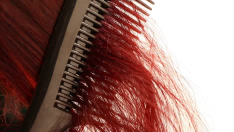 detail-of-combing-curly-red-hair,-slow-motion-close-up-shot