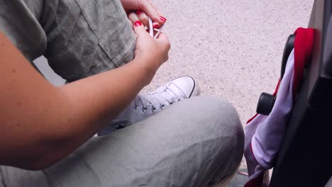 Girl-lacing-up-her-converse-all-stars-brand-white-trainers-in-slow-motion