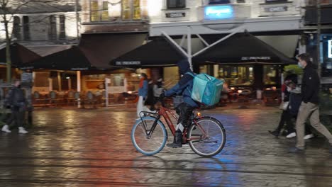 El-Ciclista-De-Deliveroo-Llega-Con-Una-Bicicleta-Eléctrica-Al-Restaurante-Para-Recoger-Pedidos-De-Comida-Y-Entregar-Pedidos-Para-Clientes-Y-Clientes---Gante,-Bélgica