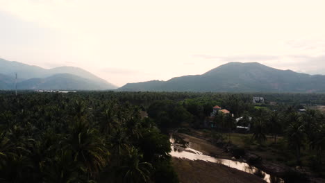 Vista-Aérea-De-La-Aldea-Rural-Cam-Ranh-En-La-Selva-Tropical-De-Vietnam,-Drones-Vuelan-Sobre-El-Paisaje-Montañoso-En-Asia