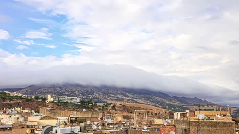 Movimiento-De-Nubes-Sobre-El-Paisaje-Urbano-De-Fez,-Marruecos-En-Timelapse-Con-La-Vista-Del-Terreno-Montañoso-En-El-Fondo