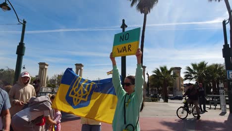 Women-holding-up-"No-War"-sign-and-Ukrainian-flag-at-peace-rally