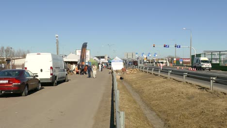 People-Walking-On-The-Road-And-Cars-Parked-Within-The-Area-Of-Ukrainian-Polish-Customs-Border-Crossing-In-Dorohusk,-Poland--Static