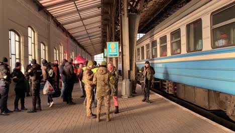 Ein-Zug-Voller-Flüchtlinge-Bereit,-Den-Lemberger-Bahnhof-Zu-Verlassen,-Während-Soldaten-Und-Polizisten-Bereitstehen