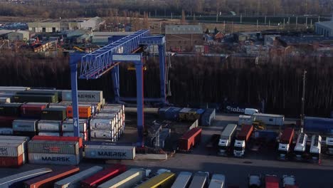 Versandcontainer-Kranlift,-Der-Schwere-Fracht-Exportkistencontainer-In-Der-Werft-Entlädt,-Luftaufnahme,-Nach-Oben-Kippende-Umlaufbahn,-Linke-Aufnahme