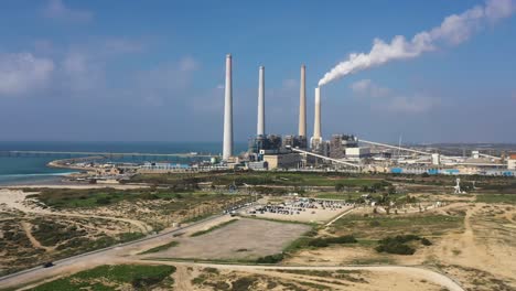 Hadera-Park,-Orot-Rabin-Power-plant-aerial-tracking-shot-with-blue-sky-and-view-of-the-Mediterranean-sea