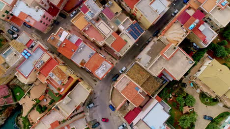 Aerial-bird's-eye-view-of-rooftops-of-buildings-and-houses-along-the-coast-of-Caletta-Sant'Elia,-Santa-Flavia-In-Italy