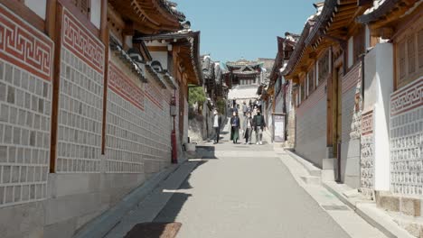Groups-of-people-in-white-masks-visit-Bukchon-Hanok-Village-in-Seoul---walking-pov