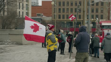 Hombre-Que-Sostiene-La-Bandera-Canadiense-Durante-Los-Movimientos-Contra-Los-Mandatos-Covid-19-En-Ottawa,-Canadá