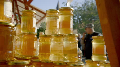 Schnelle-Pfanne-Zu-Gestapelten-Honiggläsern-Auf-Dem-Von-Der-Sonne-Beleuchteten-Markt