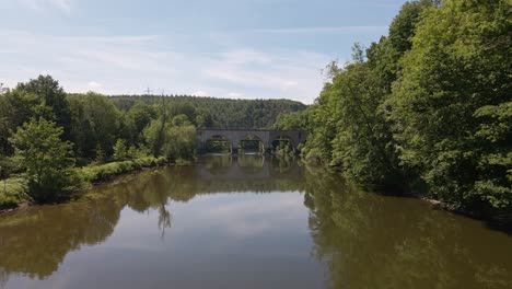 Old-brick-train-trestle-leading-over-the-Sieg-river-near-Schladern,-Germany-on-a-sunny-spring-day