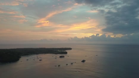 Spectacular-aerial-view-flight-panorama-curve-flight-drone-footage-after-a-dream-sunset-with-colourful-clouds-mirroring-at-Mushroom-Bay-Lembongan