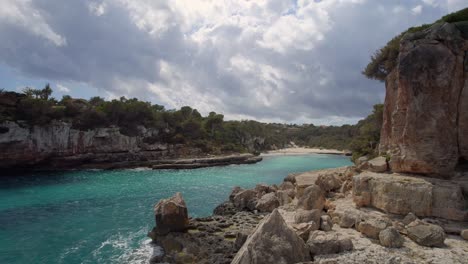 Flying-along-the-Majorcan-coast-and-through-the-rocky-entrance-to-a-secluded-beach