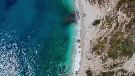 Der-Unberührte-Türkisfarbene-Strand-Mit-Weißem-Sand-Reflektiert-Das-Sonnenlicht-Auf-Der-Wasseroberfläche