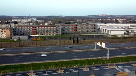 Aerial-view-of-"École-Nationale-de-l'Aviation-Civile",-A62-highway,-new-park-of-Montaudran,-"Halle-de-la-Machine"-with-the-city-of-Toulouse-in-the-background