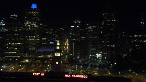 Aerial-view-of-the-Illuminated-port-of-San-Francisco,-USA---pull-back,-drone-shot