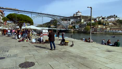 Schwenkaufnahme-Eines-Touristen,-Der-Am-Flussufer-Des-Flusses-Douro-Entlang-Spaziert-Und-In-Porto-Einkauft