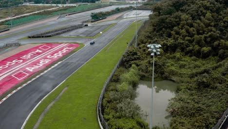 Aerial-view-of-a-fast-lotus-car-driving-on-a-race-track-and-passing-the-audio-logo-at-Ningbo-circuit