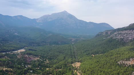 Aerial-scenic-view-on-a-hazy-day-with-the-peaks-of-the-rough-Taurus-Mountain-landscape-in-the-distance-through-the-valley-of-Antalya-Turkey