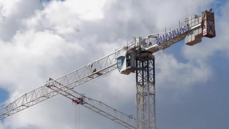 Working-Construction-Tower-Crane-Against-Cloudy-Sky-On-A-Sunny-Day