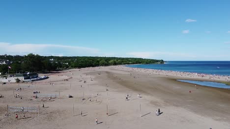 Flying-over-people-playing-volleyball-on-a-Toronto-beach-on-Lake-Ontario-in-the-summer