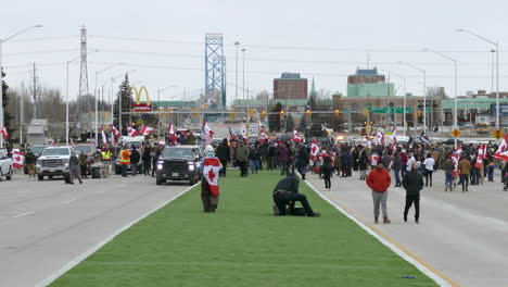 Crowds-of-people-getting-hold-back-by-armored-police-and-a-blockade-on-the-street-in-Canada,-Windsor,-Ontario