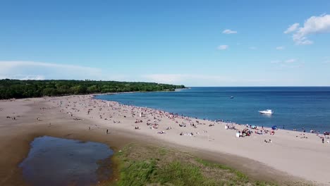 Flying-over-a-crowded-Toronto-beach-with-boats-on-Lake-Ontario