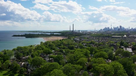 Flying-over-the-coast-of-Lake-Ontario-on-a-summer-day-with-a-beach-and-the-Toronto-skyline-in-the-background