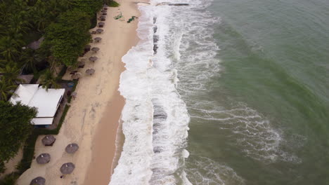 Aerial-forward-view-of-a-beautiful-beach,-with-coastal-erosion-made-by-a-typhoon